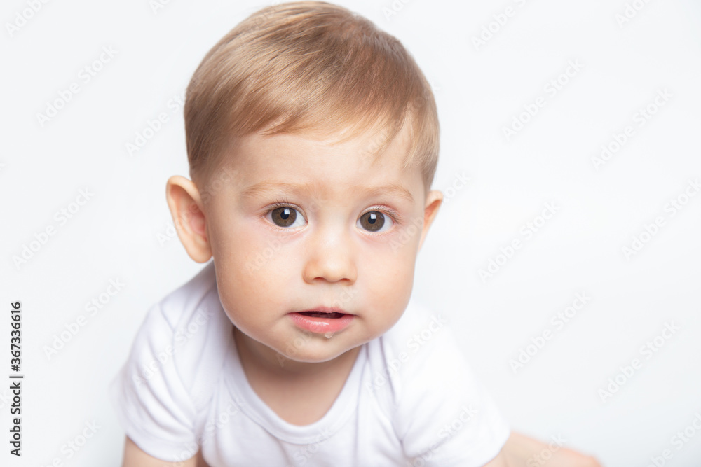 caucasian baby boy drooling dressed in a white t-shirt on a white background closeup caucasian baby boy drooling dressed in a white t-shirt on a white background closeup