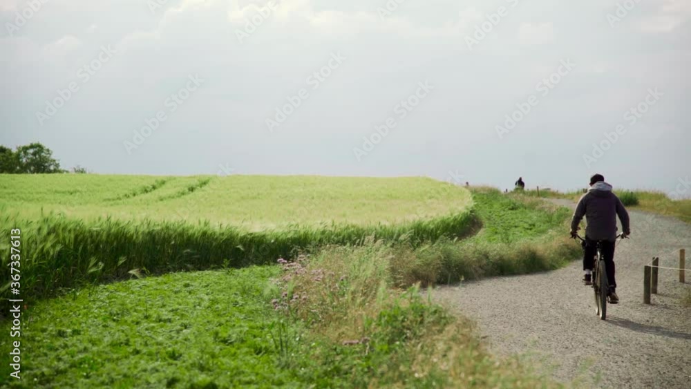 Man riding his bike on path next two beautiful scenery Man riding his bike on path next two beautiful scenery