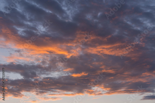 Fototapeta Naklejka Na Ścianę i Meble -   Chmury na niebie oświetlone czerwonym światłem zachodzącego słońca.
