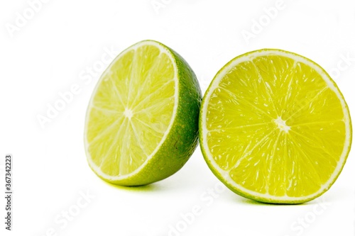 Bright juicy green lime on a white background cut in half.