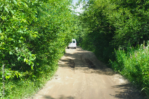 Fototapeta Naklejka Na Ścianę i Meble -  Car driving on a country road in the forest, off road, summer adventure