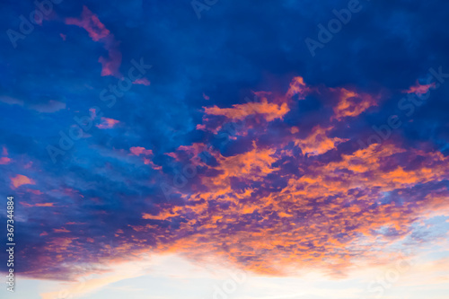 Clouds at sunset illuminated by the sun from below. Blazing sky, dramatic sunset. Sky is like a conflagration, majestic atmosphere