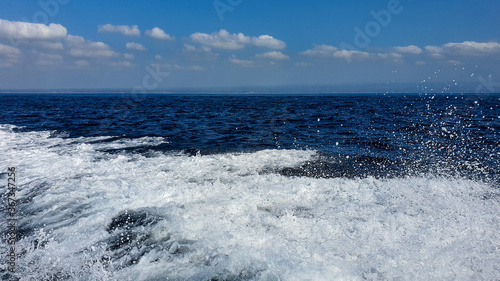 View of the ocean waves and the blue sky from a fast boat in Bali, Indonesia. Bali fast boat ride in Summer