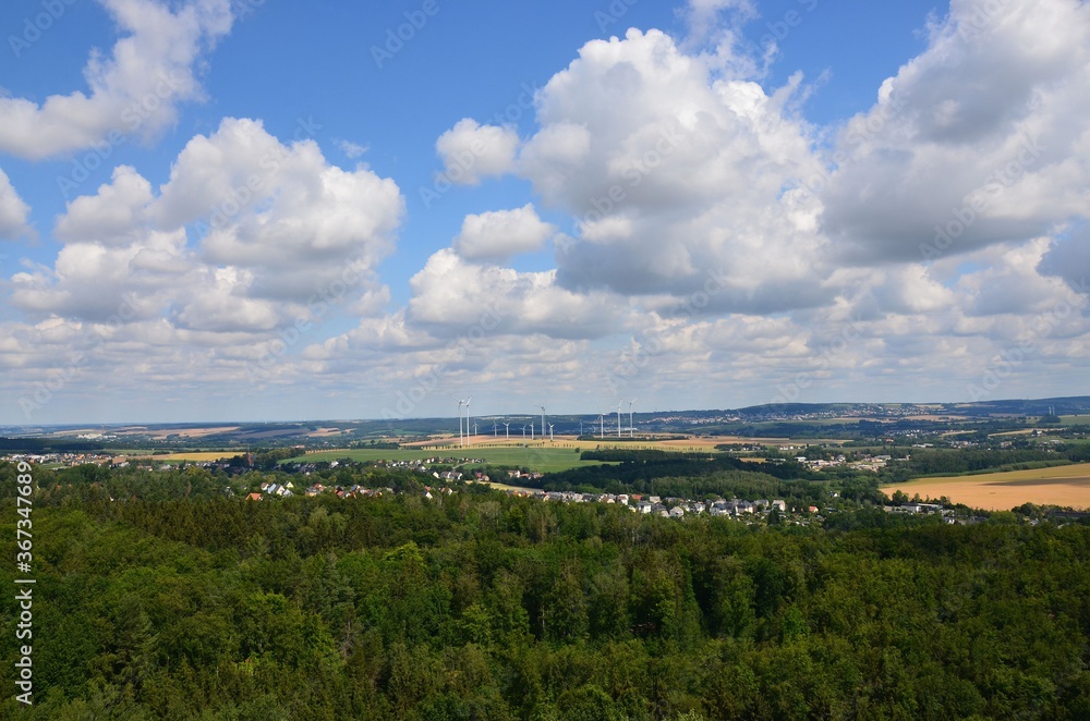 Ausblick über Wald und Hügellandschaft im Sommer mit Wolkenhimmel