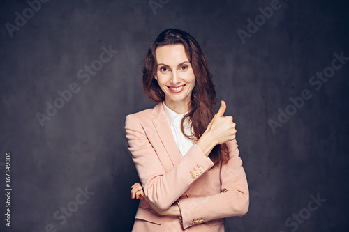 caucasian woman show thumb up on dark background