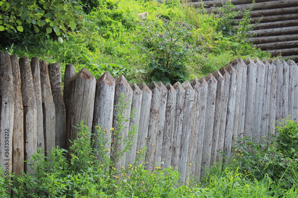 Old fence made of thick logs near the old fortress. Steampunk. Russia. Old fence made of thick logs near the old fortress. Steampunk. Russia.