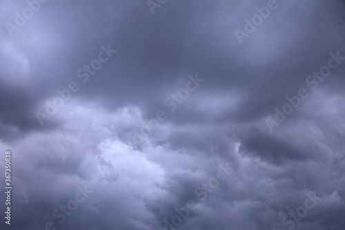 Clouds in blue dark sky. White, fluffy clouds In blue sky. Background nature. Texture cumulus floating on blue sky. Backgrounds concept. Environment, atmosphere. Place for an inscription or logo