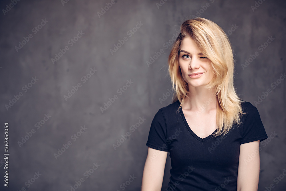 Winking young caucasian girl on dark background Winking young caucasian girl on dark background