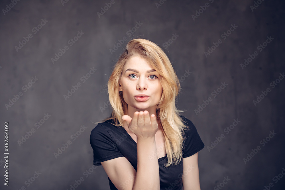caucasian girl blowing kiss on dark background caucasian girl blowing kiss on dark background