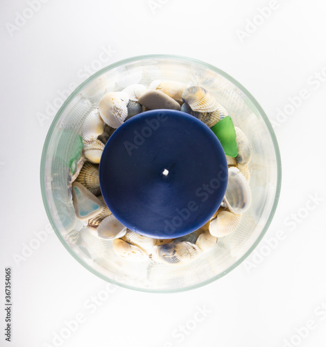 Blue candle in a vase full of seashells