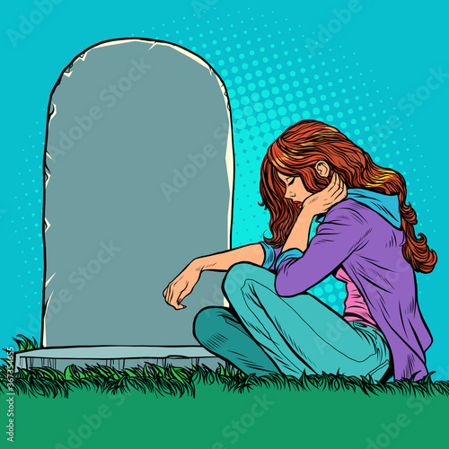 A sad widow or daughter near a grave in the cemetery. Memorial day, veteran father or husband.