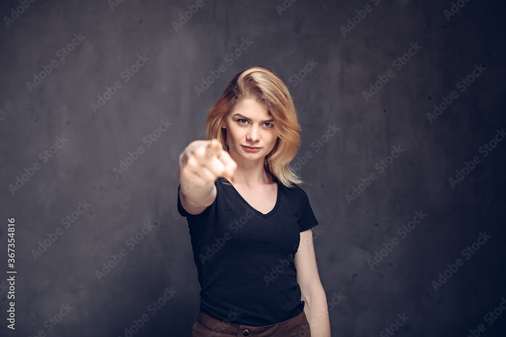 young girl point with finger on dark background young girl point with finger on dark background