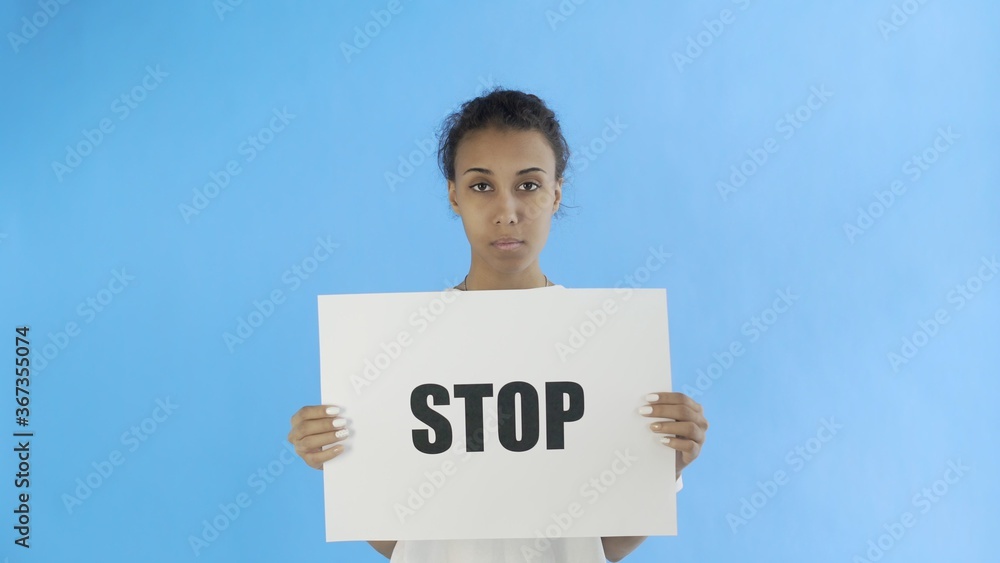Afro-American Girl Activist With Stop Poster on blue background Afro-American Girl Activist With Stop Poster on blue background