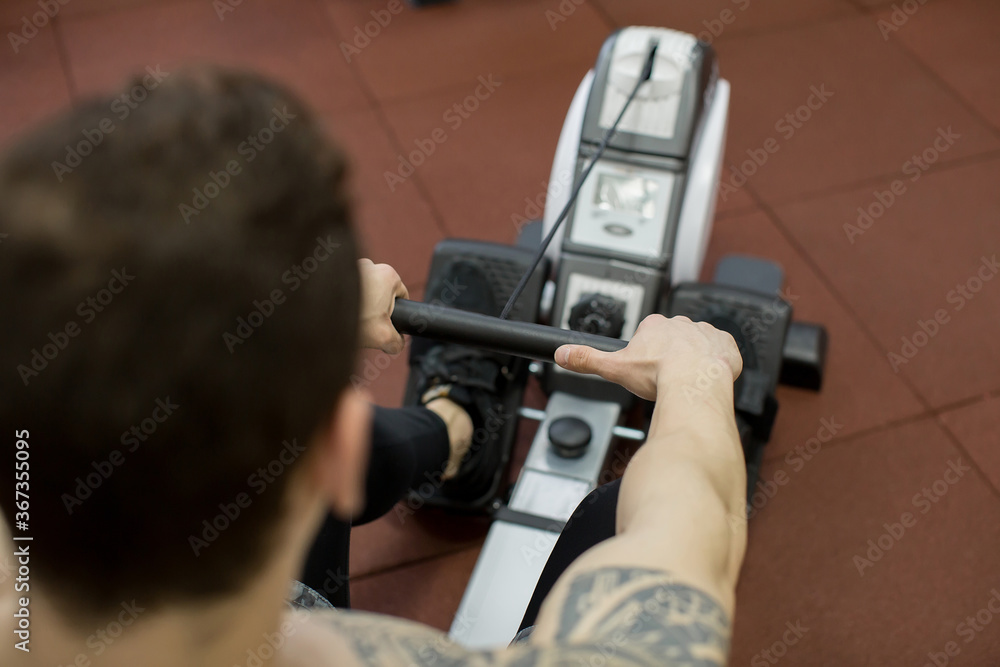 Man running rowing exercise in the gym Man running rowing exercise in the gym