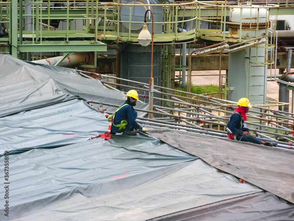 Naklejka premium Contractors work and are using tools in industrial plants
