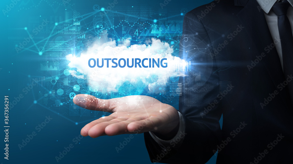 Hand of Businessman holding OUTSOURCING inscription, successful business concept Hand of Businessman holding OUTSOURCING inscription, successful business concept