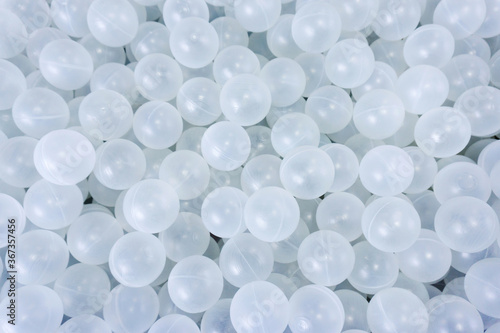 Lots of white, plastic balls. View from above. Close-up