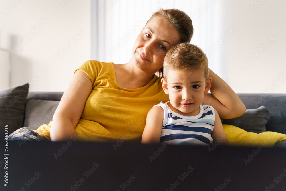 Fototapeta premium Small caucasian boy having video call online with his mother while watching content on laptop - Little child son sitting by his mom at home in front of the computer - childhood real people concept