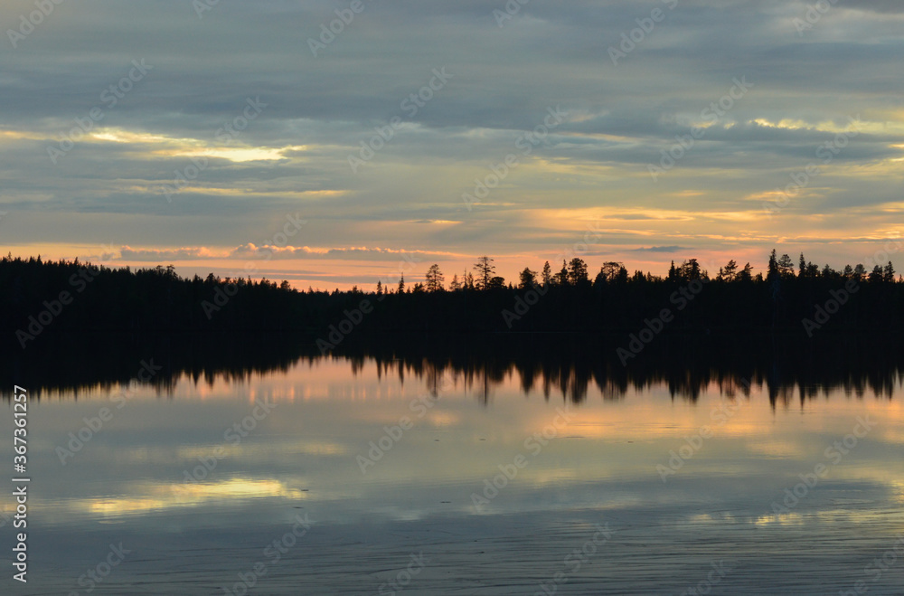 Finnish summer night. Lake and sunset. Fading light, pastel colors. Serene and beautiful nature.
