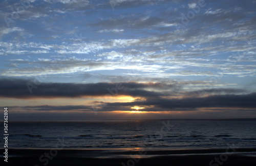 Beach scene beautiful sunset and dynamic clouds over Pacific Ocean