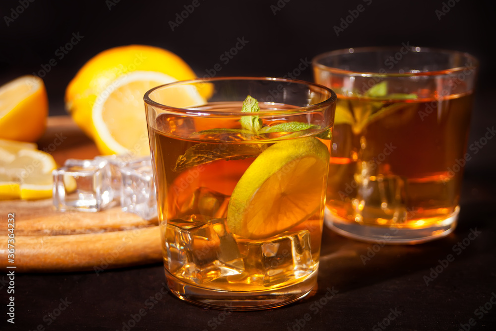 Fresh cocktail Cuba Libre with brown rum, cola, mint and lime on black background. Long Island Iced Tea cocktail. Fresh cocktail Cuba Libre with brown rum, cola, mint and lime on black background. Long Island Iced Tea cocktail.
