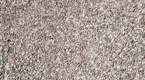 Gravel texture Small stones, little rocks, pebbles in many shades of grey, white, brown, pink colour. Crushed granite texture. Road made of stones. Small rock background. Banner for web site