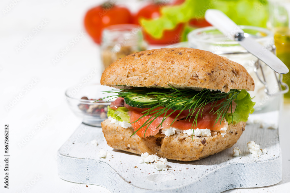 sandwich with salted fish, fresh vegetebles and cream cheese on white wooden board sandwich with salted fish, fresh vegetebles and cream cheese on white wooden board