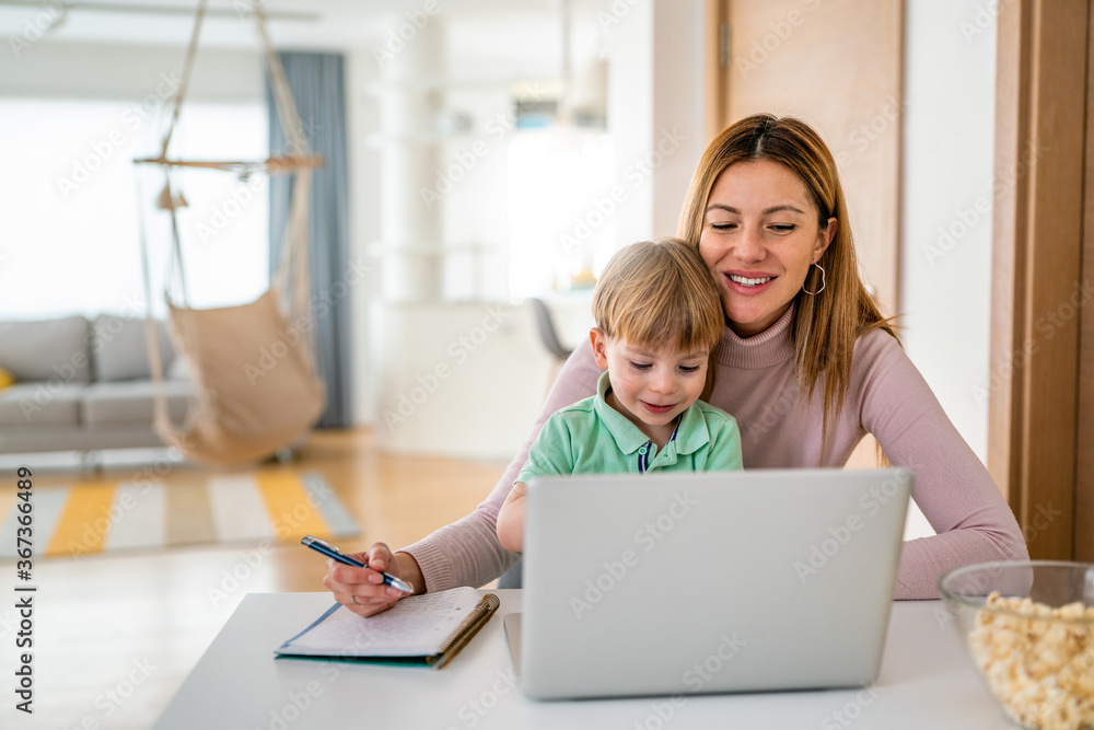 Businesswoman mother woman with a toddler working at the computer at home Businesswoman mother woman with a toddler working at the computer at home