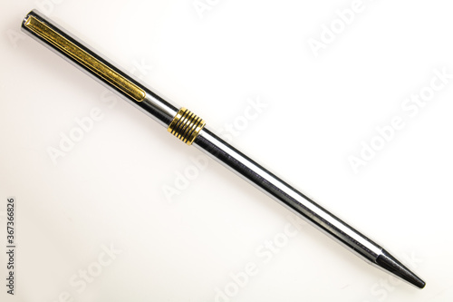 metal pen, with golden and silver colors, in a transversal position, on a white background