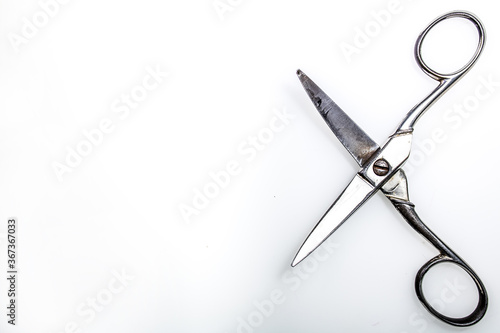 open metal scissors, silver in color, placed on a white surface