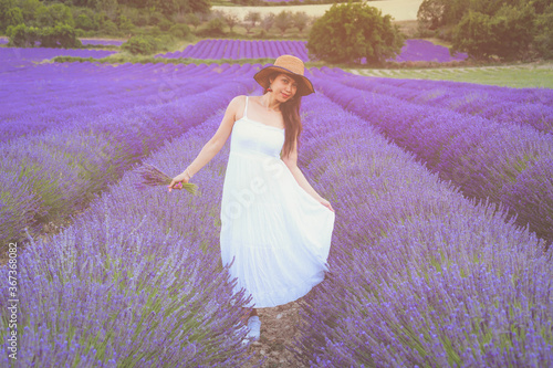 Asian woman in white dress and hat walking on the lavender field