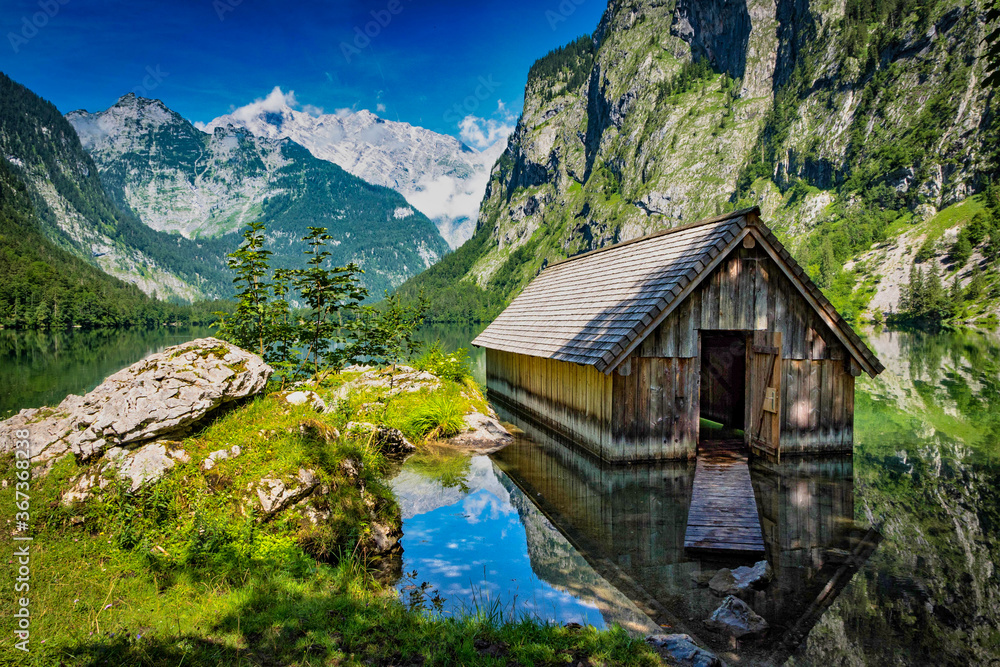 Beautiful house at the lake Obersee and green mountains in bavaria, germany in the summer.