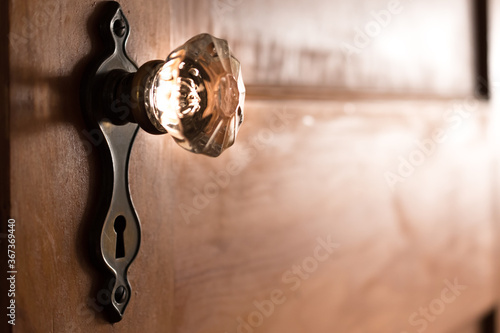 Glass Door Knob Hardware with Antique Cover Plate and Keyhole on an Old Wooden Door