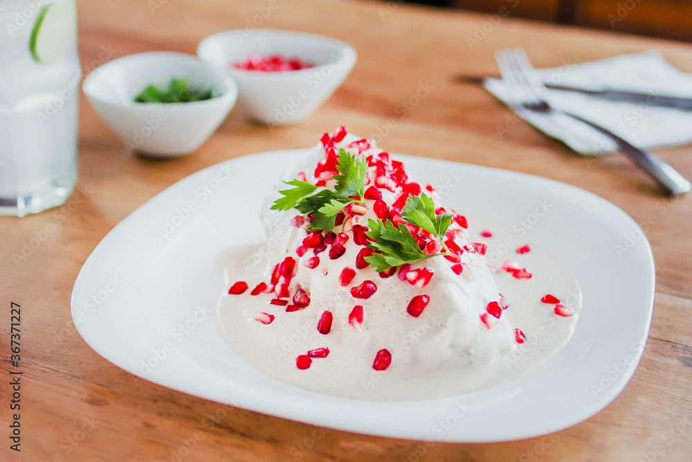 chiles en nogada, traditional Mexican dish with poblano chili peppers and walnut sauce from Puebla Mexico chiles en nogada, traditional Mexican dish with poblano chili peppers and walnut sauce from Puebla Mexico
