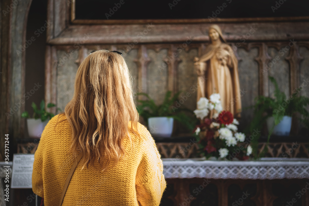 Woman praying to Virgin Mary in church. Faith and hope concept Woman praying to Virgin Mary in church. Faith and hope concept