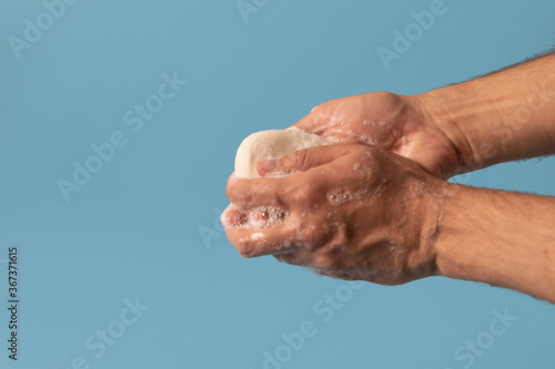 Washing hands with soap isolated on blue background.