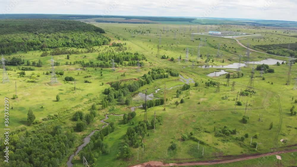 electrical transmission towers road and river in wide valley electrical transmission towers road and river in wide valley
