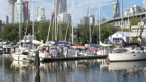 boats parked at granville island with vancouver house backdrop photo