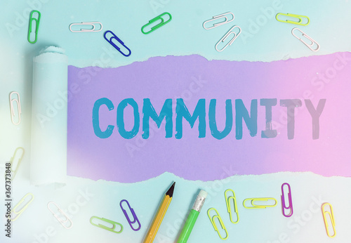 Text sign showing Community. Business photo showcasing group of showing with a common characteristics living together Rolled ripped torn cardboard placed above a wooden classic table backdrop photo