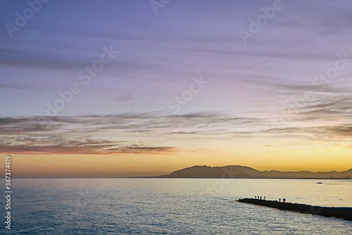 Landscape of Mediterranean sea at sunset with fishermen