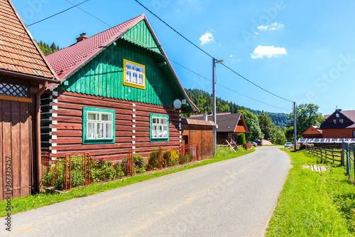 Fototapeta Naklejka Na Ścianę i Meble -  Old traditional rural wooden house along street in Osturnia village in Tatra Mountains on beautiful summer sunny day, Slovakia
