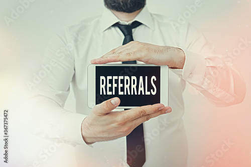 Writing note showing Referrals. Business concept for act, action, or an instance of referring to someone for work Model displaying black screen modern smartphone mock-up photo