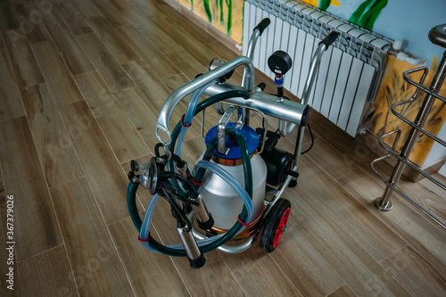 Billede på lærred Small portable compact milking machine for milking one cow