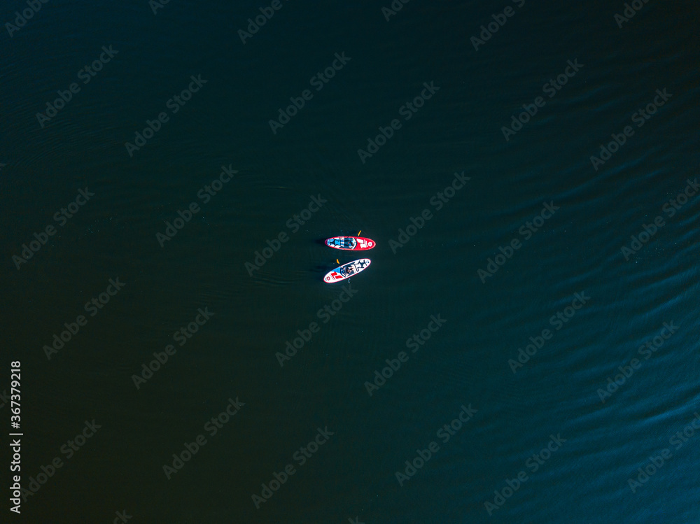 Two kayak boats are sailing along the Dnieper River. Sunny summer day, aerial drone view. Two kayak boats are sailing along the Dnieper River. Sunny summer day, aerial drone view.