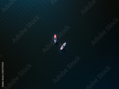 Two kayak boats are sailing along the Dnieper River. Sunny summer day, aerial drone view.