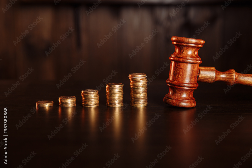TAX payment concept. Stack of coins with judge gavel. TAX payment concept. Stack of coins with judge gavel.
