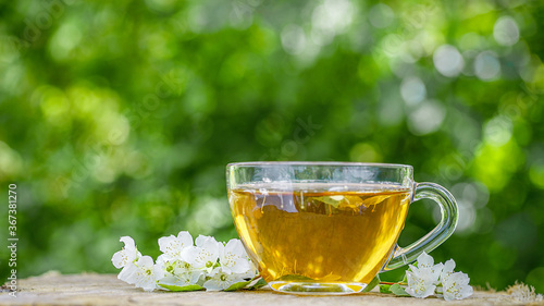 Cup of green tea with flowers jasmine. Jasmine tea and jasmine flowers on wooden background. Jasmine Flower and Leaf.