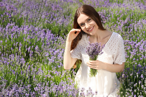 Young woman with lavender bouquet in field on summer day