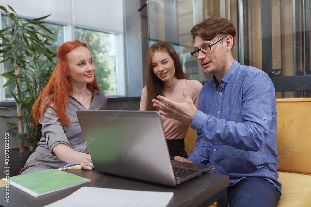 Mature businessman discussing business strategy with female co-workers Mature businessman discussing business strategy with female co-workers