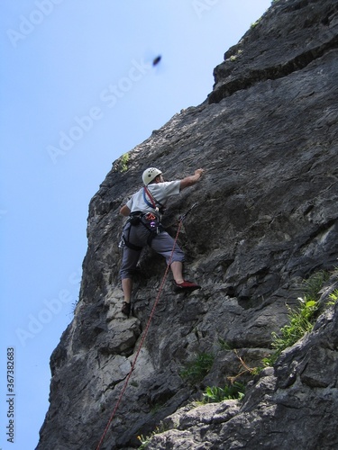Young man rock climbing on a cliff rock